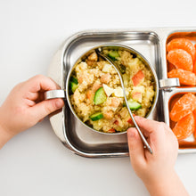 Load image into Gallery viewer, A kids holds a bowl by the handles to scoop couscous served inside a stainless steel bowl. The bowl is set on a stainless steel diivided plate. The small caviities have oranges.