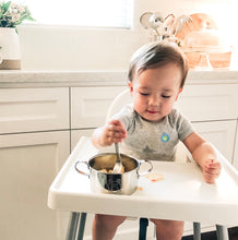 Load image into Gallery viewer, Baby is eating apple oatmeal from a Kiddobloom stainless steel bowl using a stainless steel baby safe fork.
